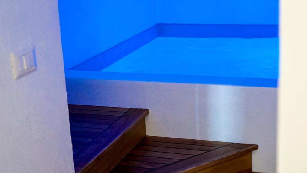 een kamer met een blauw plafond en een trap bij Il Gabbiano Suites in San Marco di Castellabate