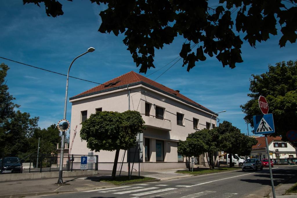 a white building with a red roof on a street at Klečka vila (apartment) with Hot tub & Sauna in Ogulin
