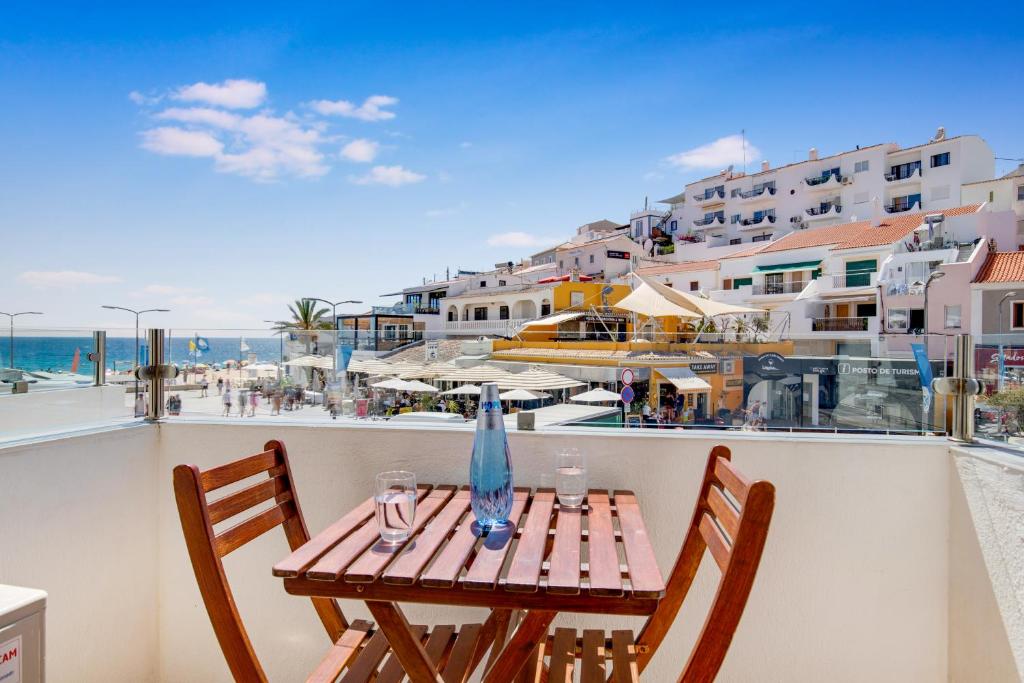 uma mesa e cadeiras numa varanda com vista para a praia em Hotel Carvoeiro Plaza em Carvoeiro