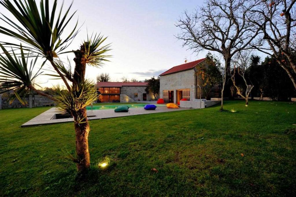 a palm tree in the yard of a house at Casas do Ermo Ermo Villas in Fafe