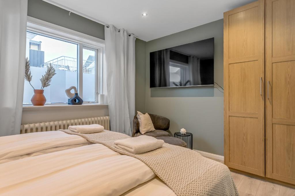 Un dormitorio con una cama grande y una ventana en Venture Vacation-Reykjavík Center, King bed, 65" TV with Netflix en Reikiavik