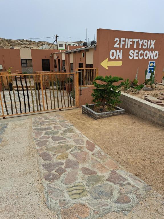 una pasarela de piedra frente a un edificio con un cartel en 2FiftySix on Second en Lüderitz
