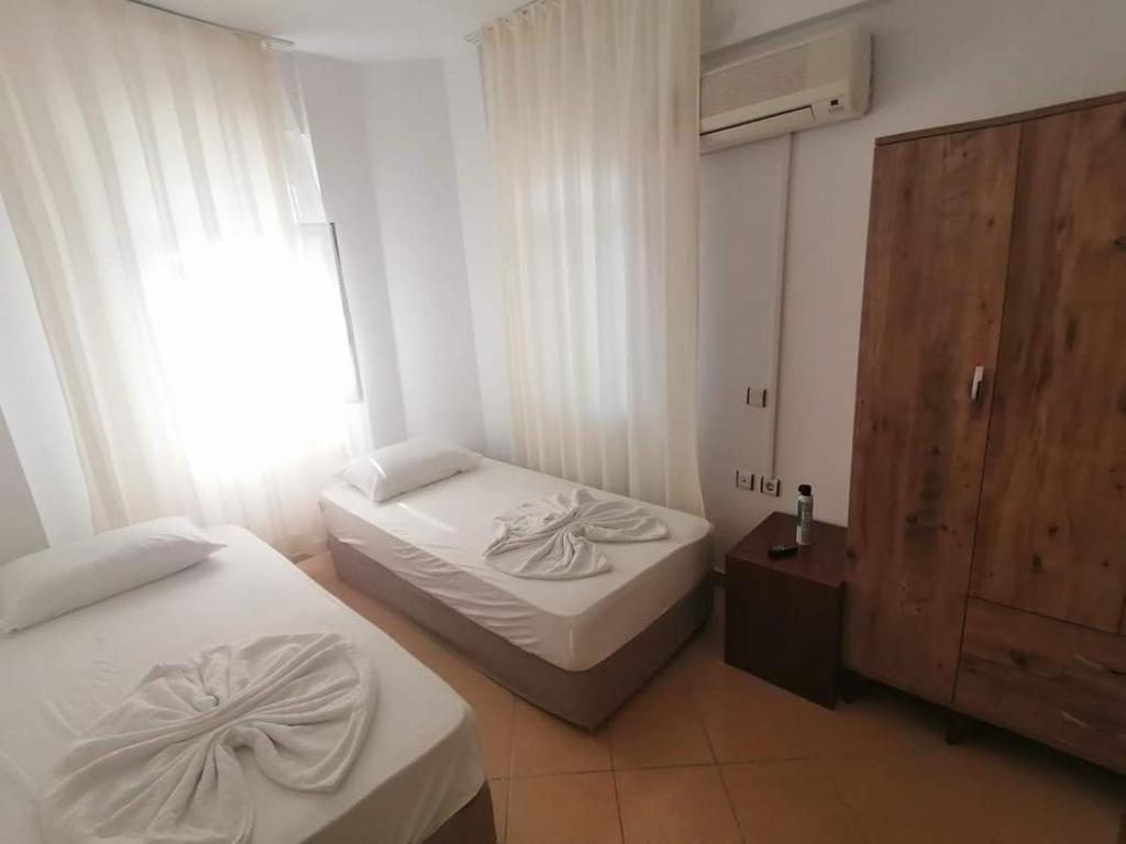 a small bedroom with two beds and a window at Villa tipindeki 3+1 in Alanya