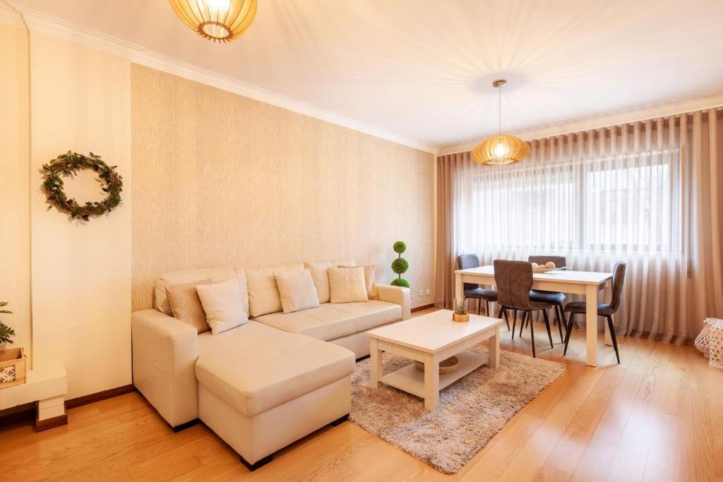 uma sala de estar com um sofá e uma mesa em Apartamento Hibiscos - Minho's Guest em Braga