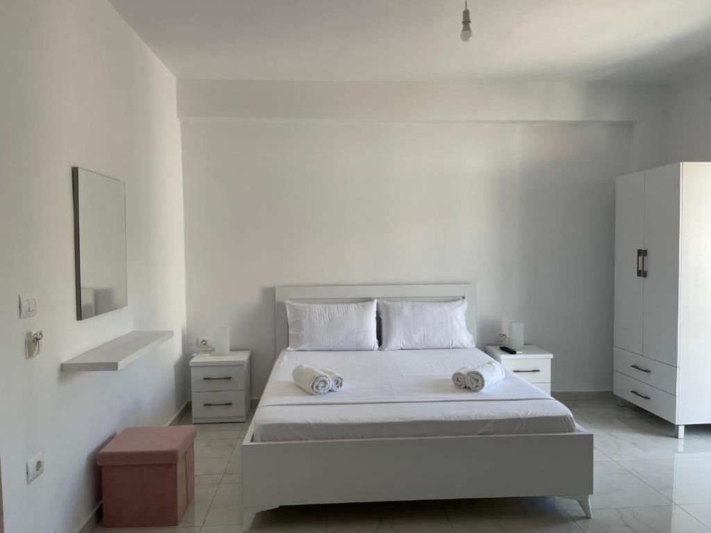 a white bedroom with a bed and a mirror at Villa Angelina Ksamil in Ksamil