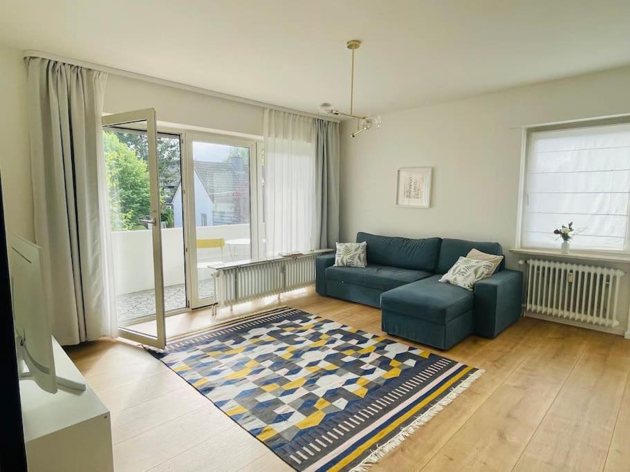 sala de estar con sofá azul y alfombra en Ferienwohnung Blau, en Bad Zwischenahn