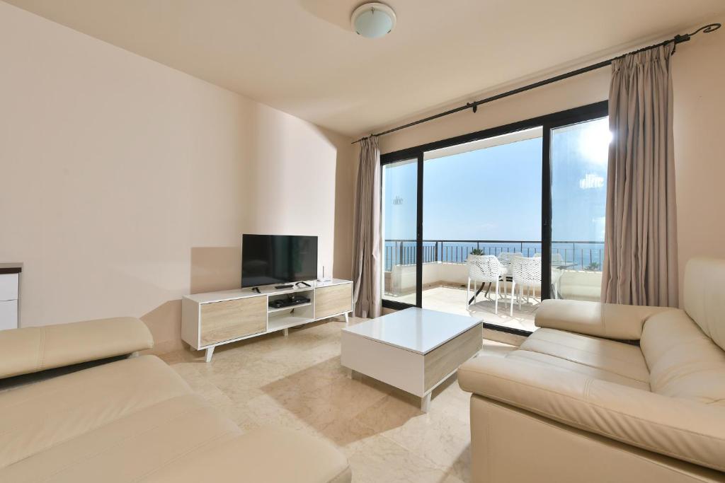 ein Wohnzimmer mit Sofa und Fernseher in der Unterkunft Apartamento con vistas al mar y parking incluido in Torrox Costa