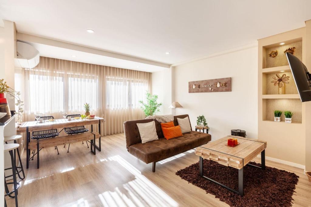 Apartamento Lírio - Minho's Guest في براغا: غرفة معيشة مع أريكة وطاولة