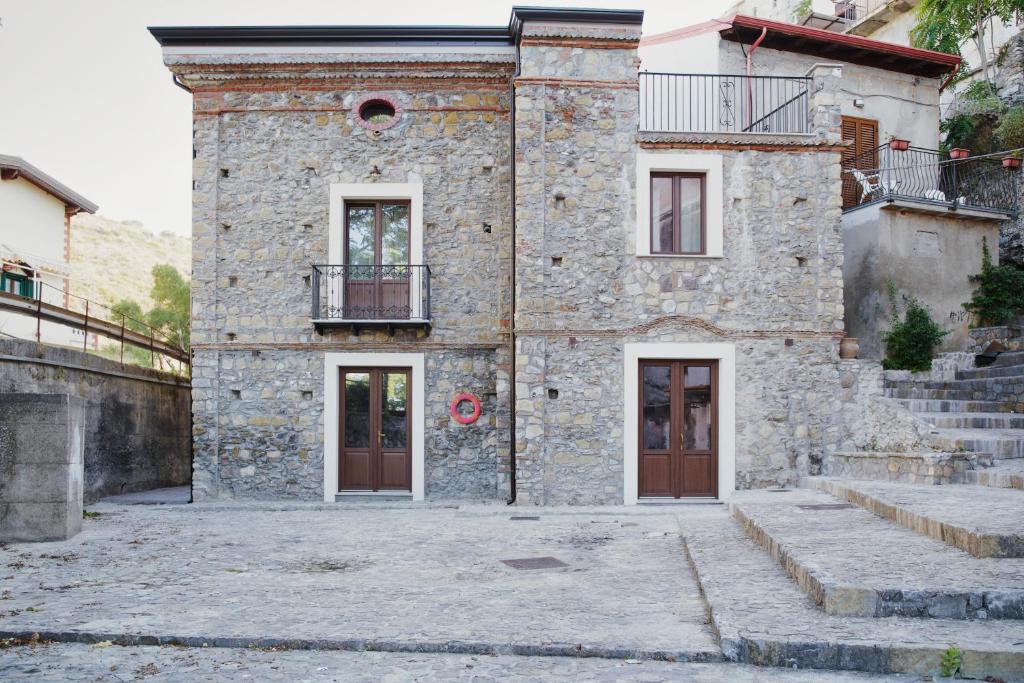 Edificio de piedra con 2 puertas y balcón en Casa Marinari en Scalea