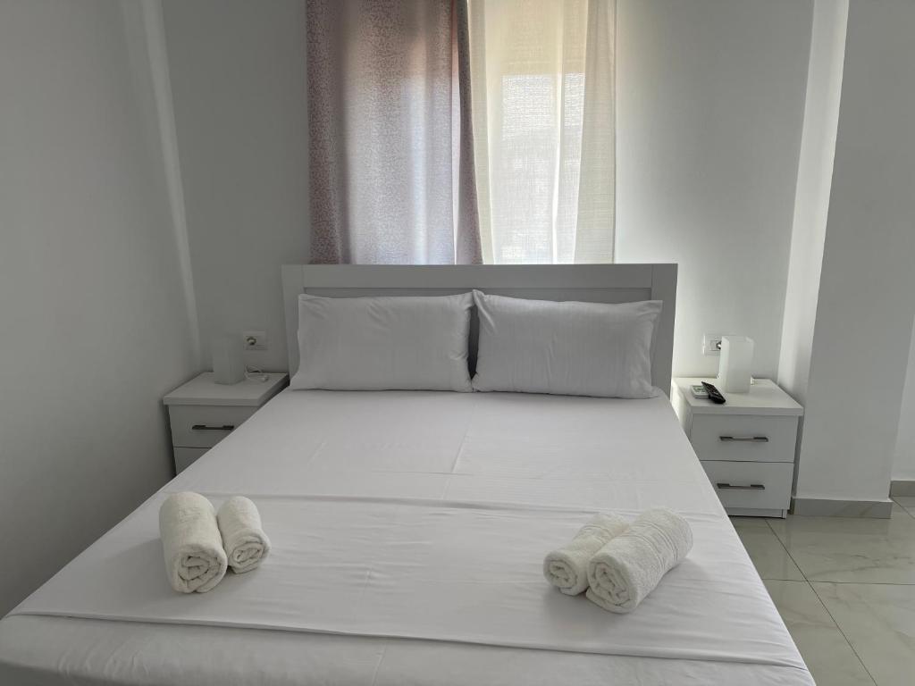 a bedroom with a white bed with two towels on it at Villa Angelina Ksamil in Ksamil