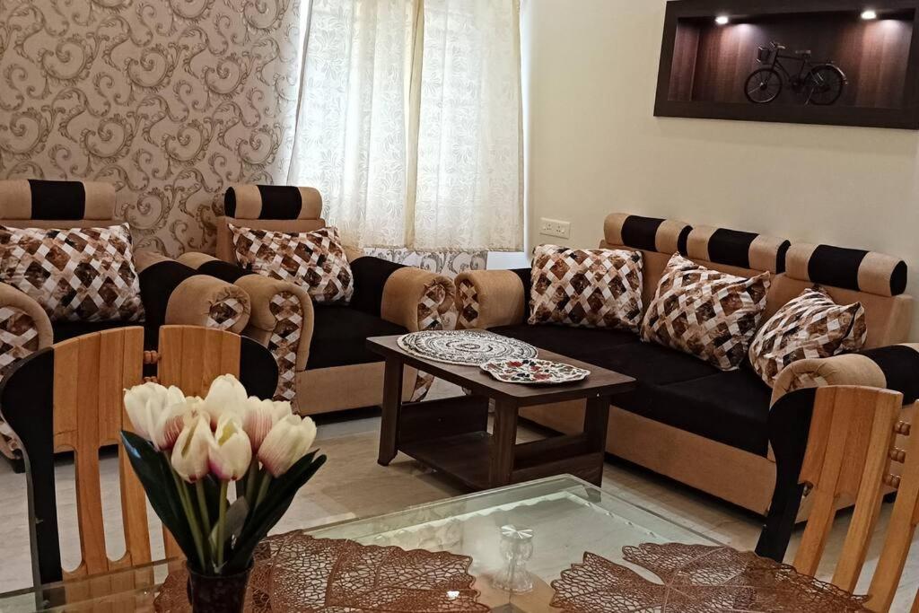 a living room with a couch and a table at SHI's Vilva AC 2BHK in Coimbatore