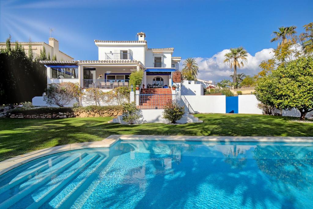 una casa con piscina frente a una casa en Villa 10 Luxe by Lirios Village Marbella en Marbella