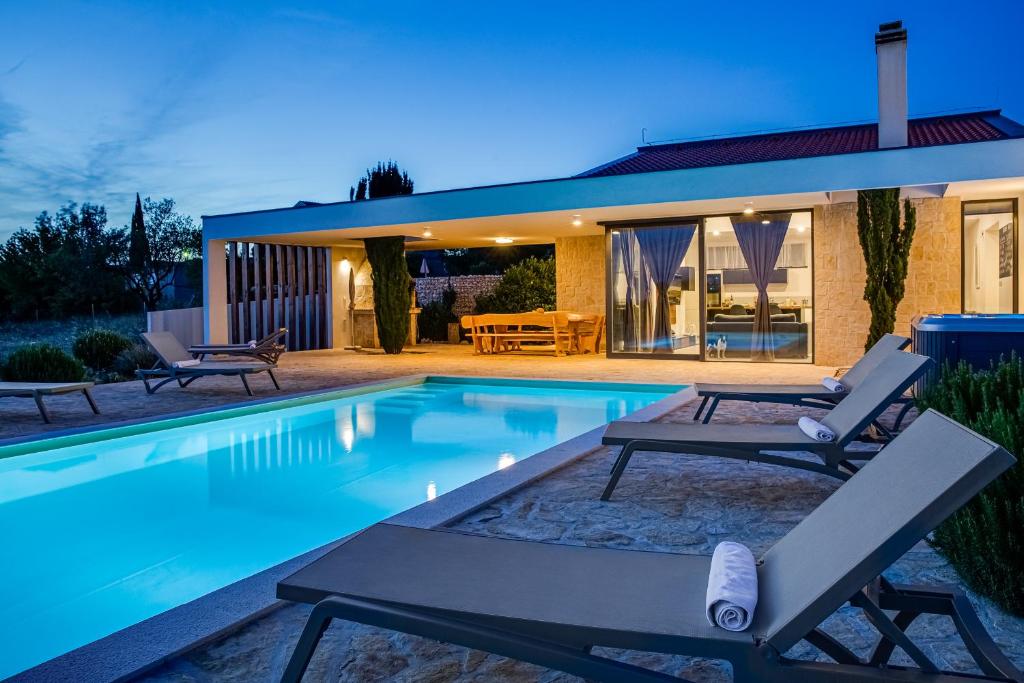 una casa con piscina frente a una casa en Villa T, spacious with heated pool & jacuzzi en Raštević