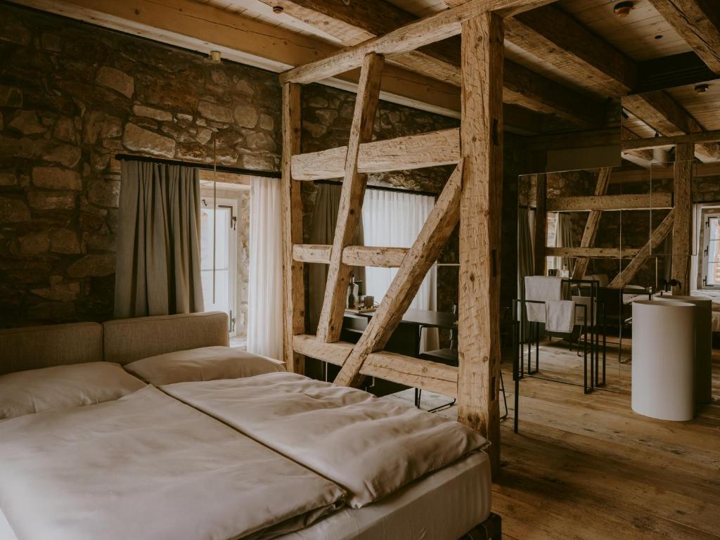 a bedroom with a bunk bed and a stone wall at 1280 Krone in Geisingen