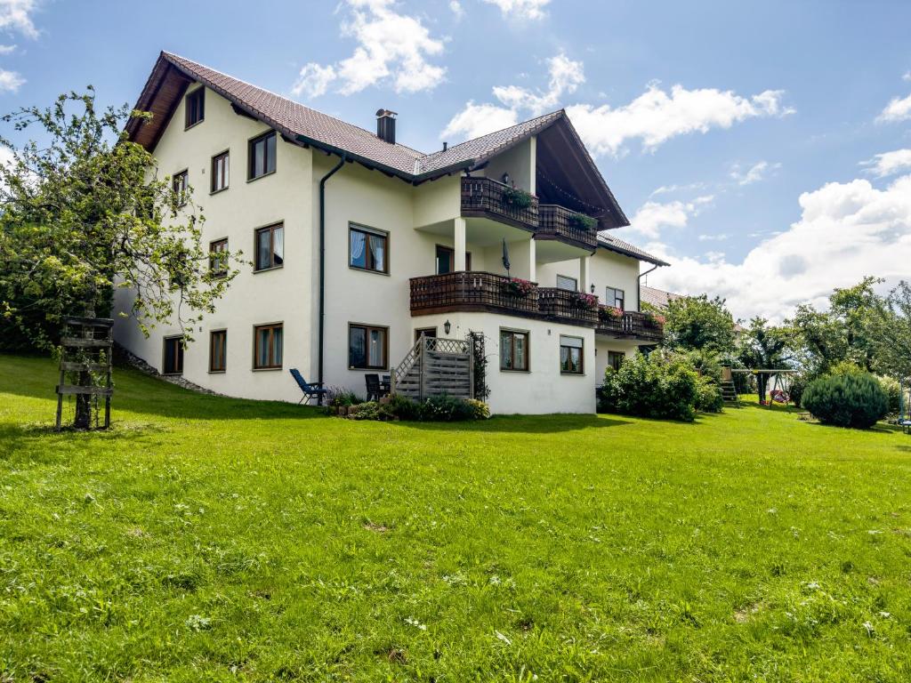 uma grande casa branca com um relvado verde em Drei-mädelhaus Ambs Wohnung 2 