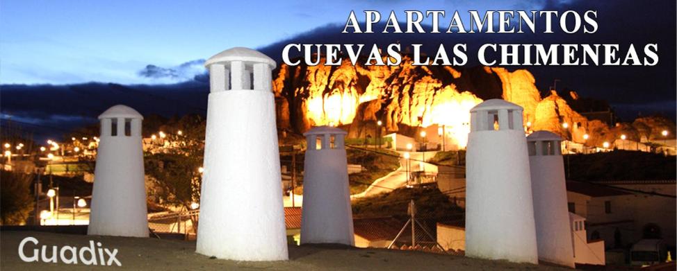 un grupo de faros blancos frente a una ciudad en Cuevas las Chimeneas en Guadix