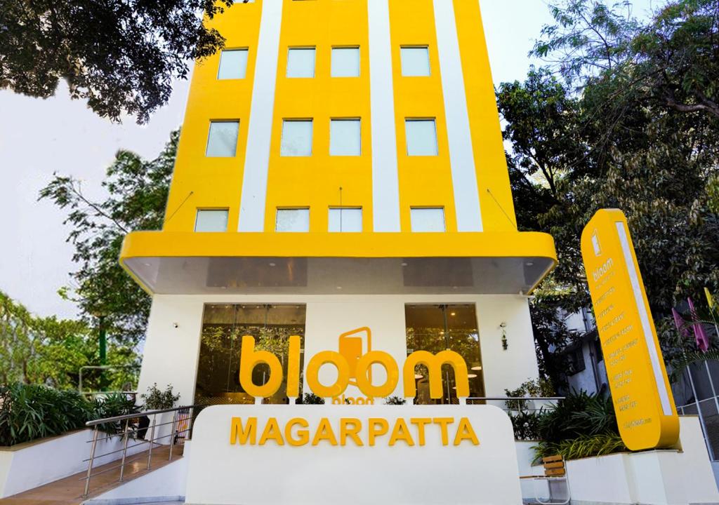 un edificio con un cartello giallo McDonalds di fronte di Bloom Hotel - Magarpatta a Pune