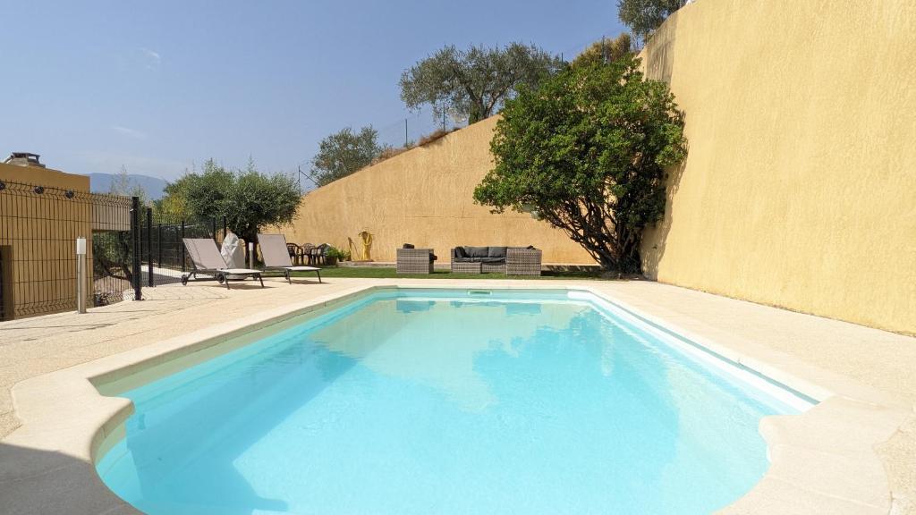 une grande piscine bleue à côté d'un immeuble dans l'établissement 3 pièces dans villa avec piscine, à Nice