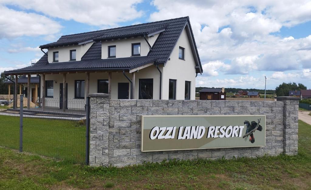 uma casa com um sinal em frente em OZZI LAND Resort em Sobącz