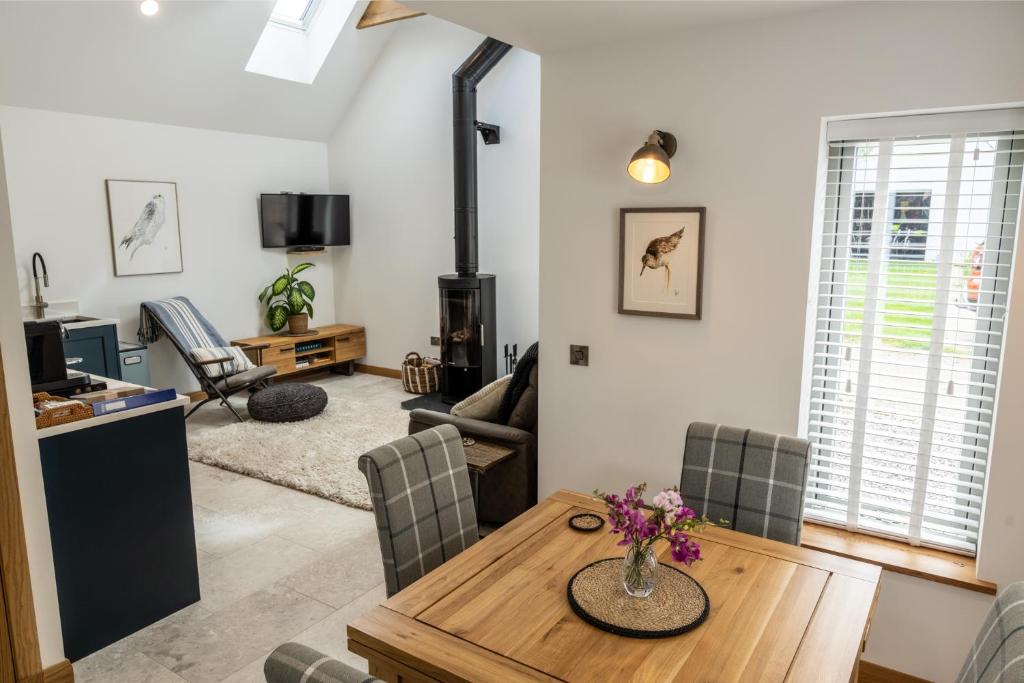 a living room with a wooden table and chairs at Lily Cottage - Brand new 1 bedroom in Forres