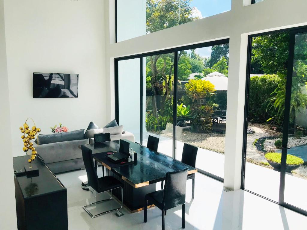 a dining room with a table and a couch at MeeTHan House in Chiang Mai