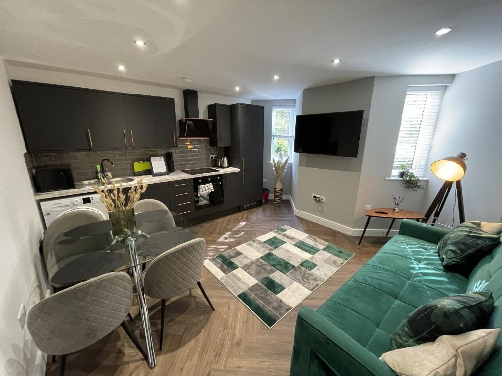 a living room with a green couch and a table at Southbank Stays Premium Apartment - Sleeps 4 in Coventry
