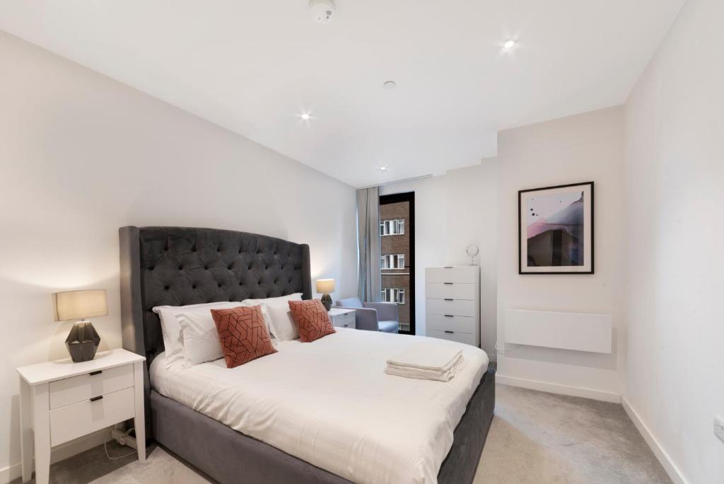 - une chambre avec un grand lit et une tête de lit noire dans l'établissement 1 Bedroom Close to Tower Hill, à Londres