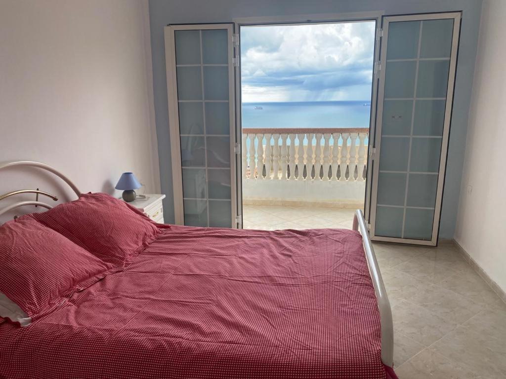 Tichi的住宿－BOUS Appartement Tichy 2，一间卧室配有一张床,享有海滩美景
