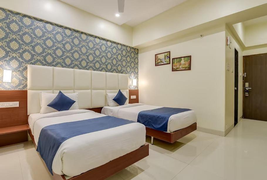 Postel nebo postele na pokoji v ubytování Magnus Square Business Hotel near Pune Airport