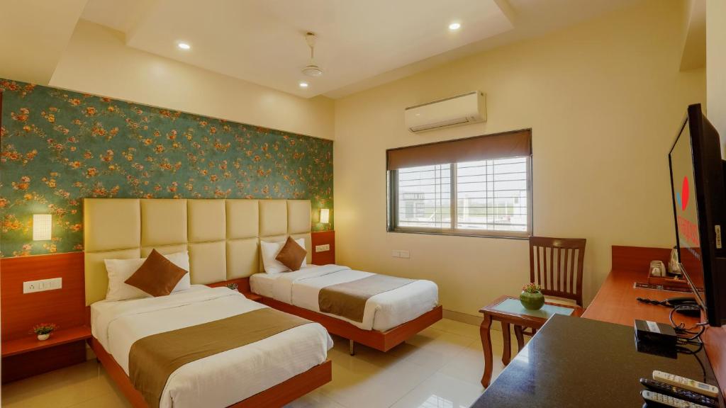 Postel nebo postele na pokoji v ubytování Magnus Square Business Hotel near Pune Airport