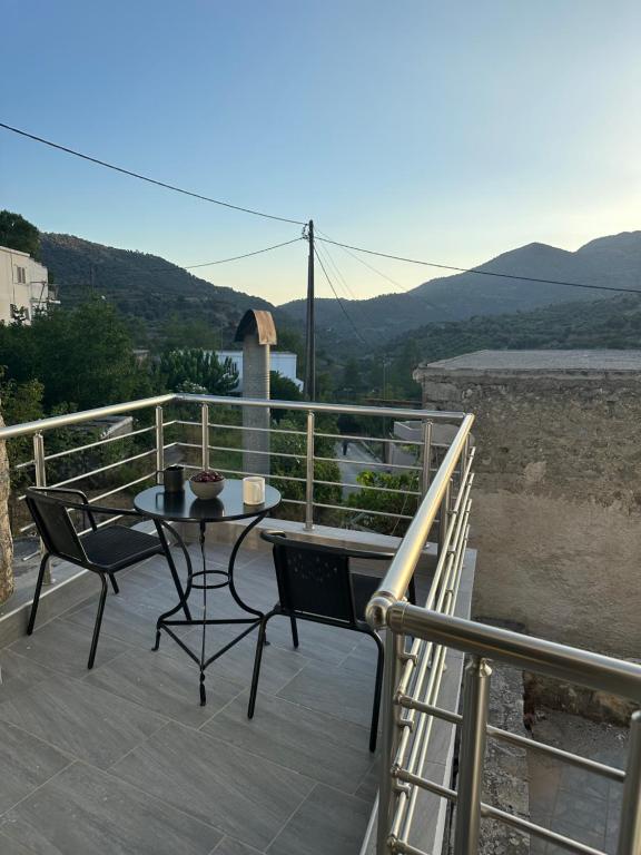 a patio with a table and chairs on a balcony at Kato Zaros Apartments in Zaros