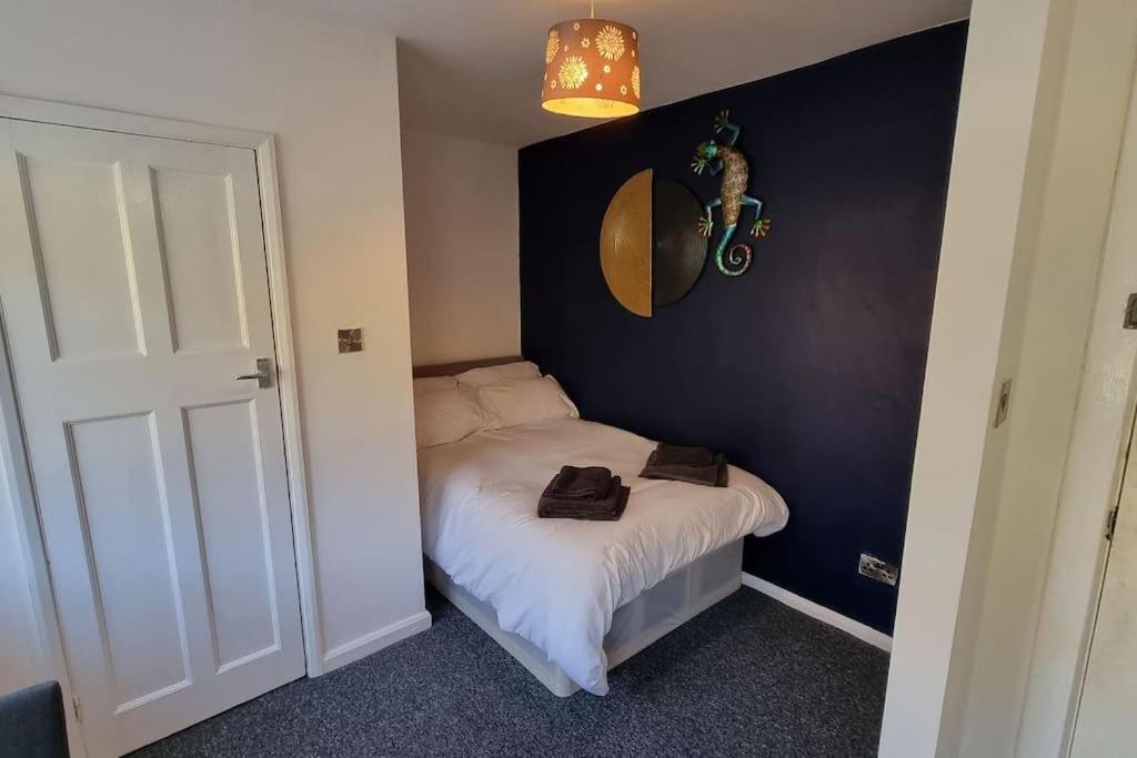 ein kleines Schlafzimmer mit einem Bett und einer schwarzen Wand in der Unterkunft Studio Flat in Nottingham
