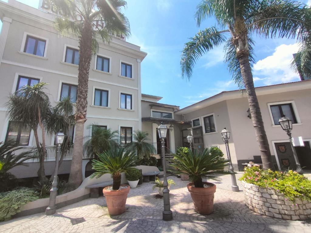 un edificio con palmeras delante en Buono Hotel, en Nápoles