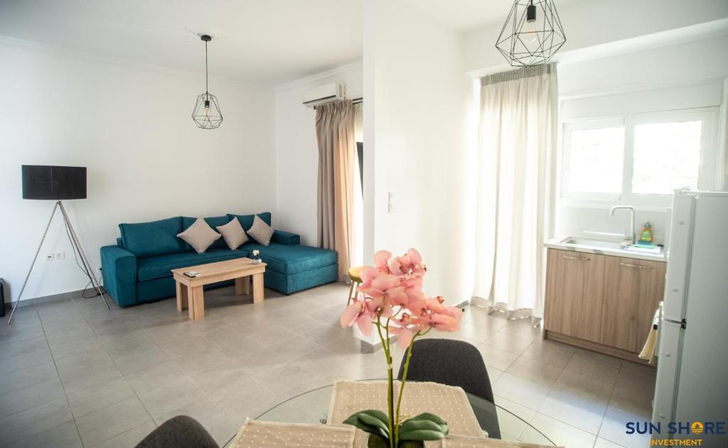 een woonkamer met een blauwe bank en een tafel bij Explore Greece from City Centre Apartment in Chalkida