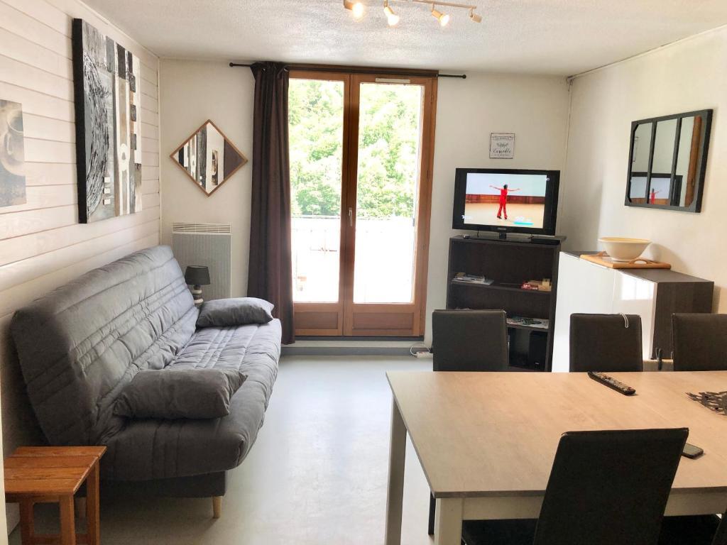 a living room with a couch and a table at Plein coeur de Barèges, appartement 4/6 personnes in Barèges