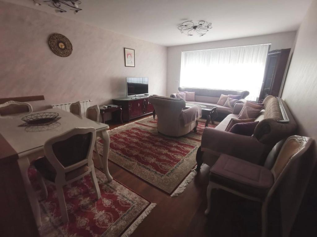 ein Wohnzimmer mit einem Sofa und einem Tisch in der Unterkunft Apartman Zvijezda, Zenica in Zenica