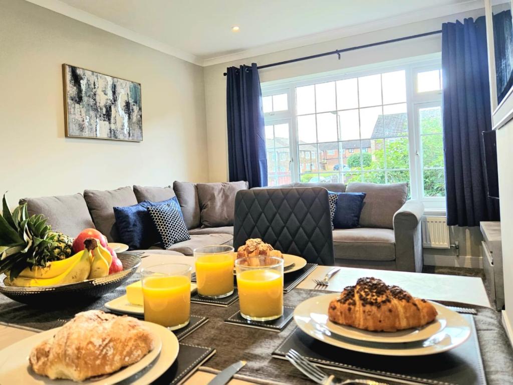 a living room with a table with food and orange juice at Potter's Escape-walking distance from The Studios! in Abbots Langley