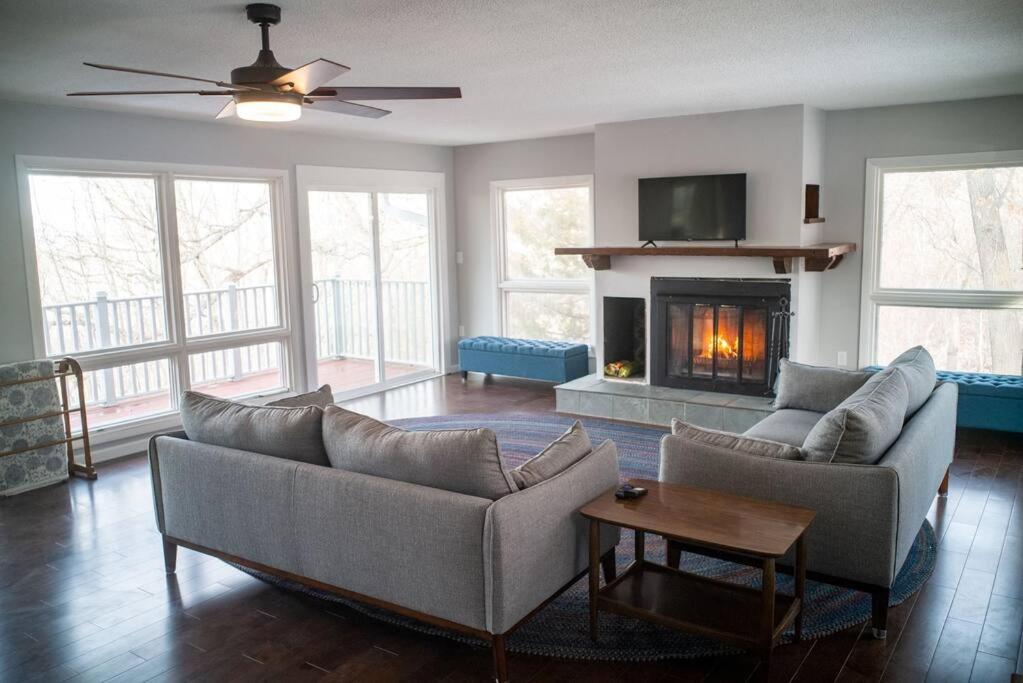 a living room with two couches and a fireplace at Finn's Hideaway -Modern family river home in Keokuk
