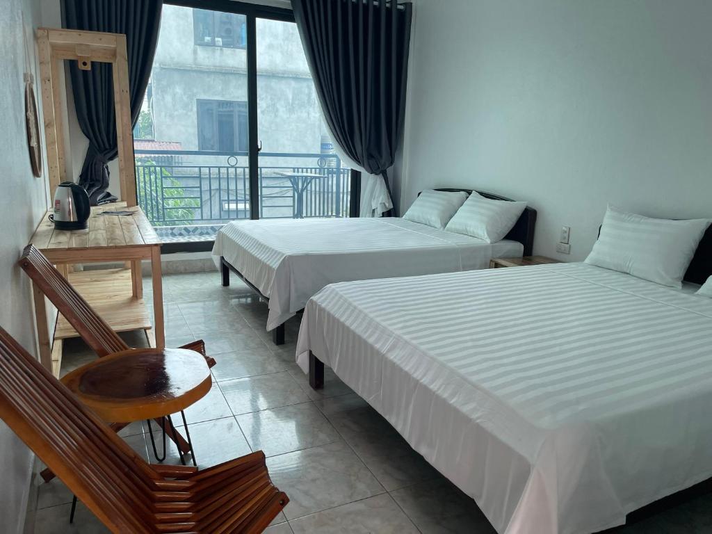 een hotelkamer met 2 bedden en een balkon bij Phước Hưng Tam Cốc Homestay in Ninh Binh