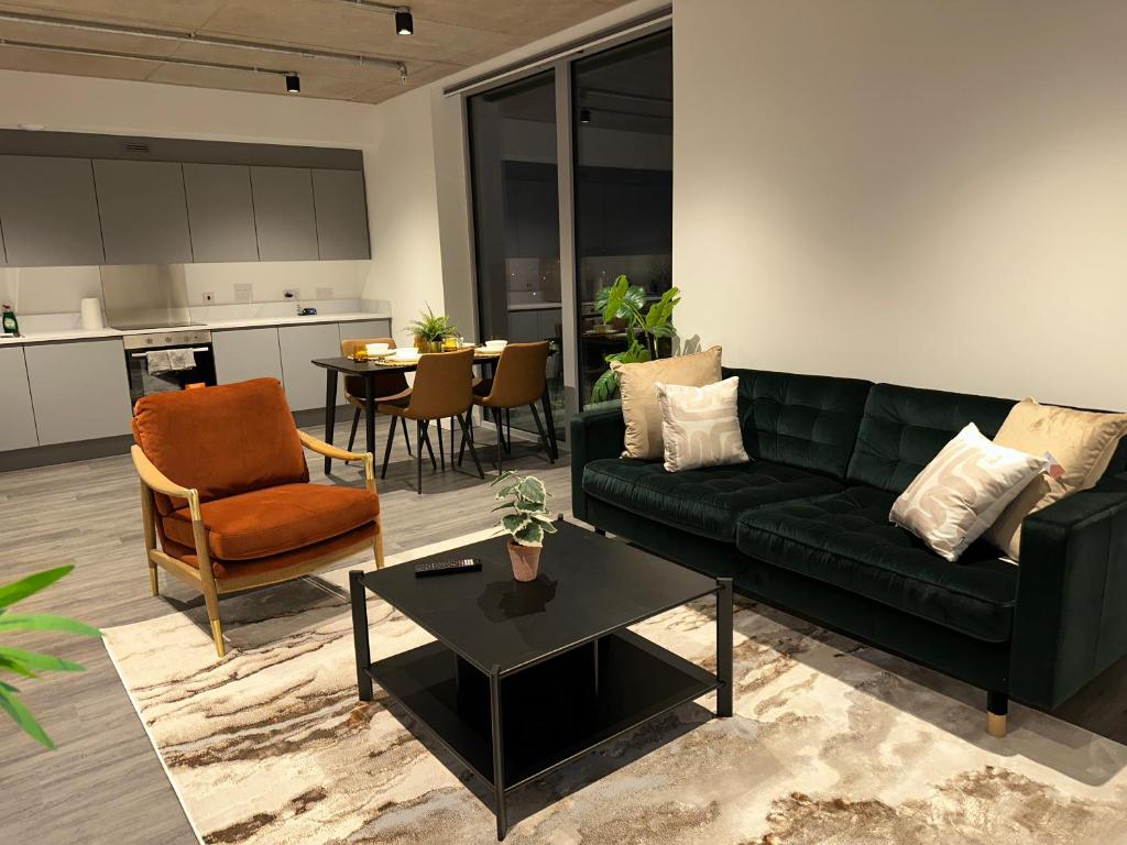 a living room with a green couch and a table at Stylish Apartment in Greenwich in Abbey Wood