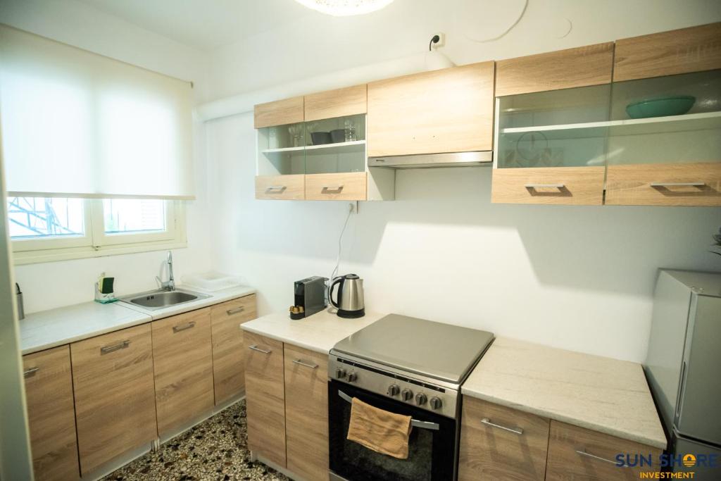 una cucina con armadi in legno e piano cottura. di Explore Greece from Apartment with Private Garden a Calcide