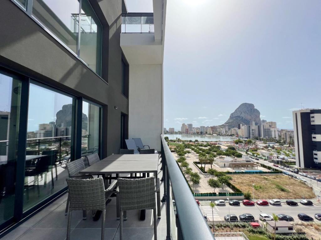 a balcony with a table and chairs and a view of a city at Beautiful duplex modern apartment in Calpe - Inmodream Calpe in Ifach
