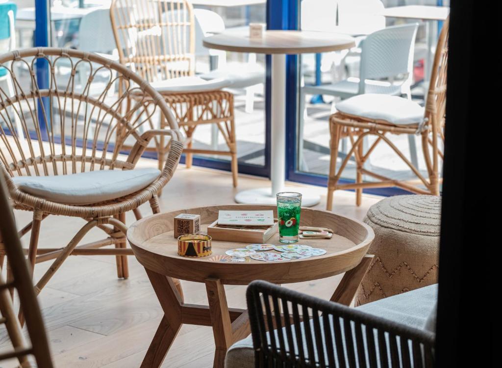 a group of chairs and a table with a drink on it at L'Escale Marine, The Originals Relais in Crozon