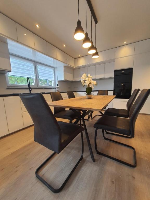 een eetkamer met een houten tafel en zwarte stoelen bij ADAM Gästehaus in Sülzetal