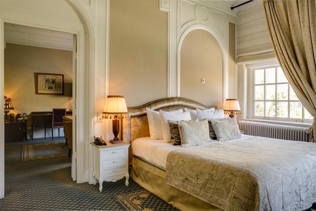 een slaapkamer met een groot bed en een raam bij Landgoed Duin & Kruidberg in Santpoort-Noord