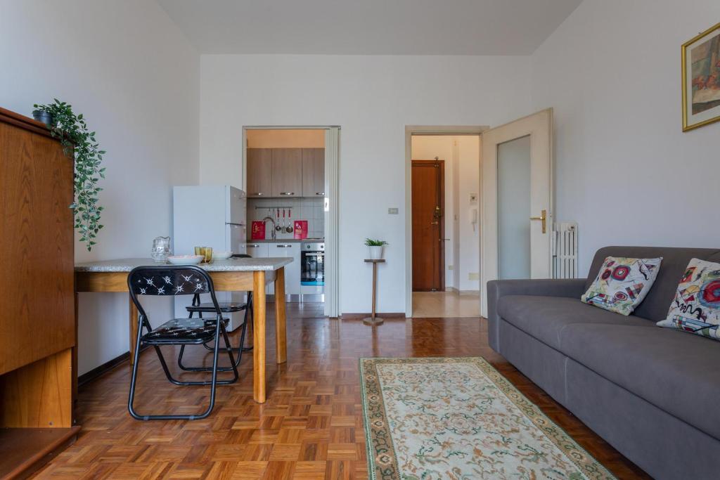 a living room with a couch and a kitchen at Little Peschiera by Wonderful Italy in Turin