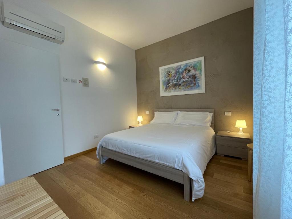 1 dormitorio con 1 cama blanca grande y 2 lámparas en Sarah Apartment Verona Fiera, en Verona