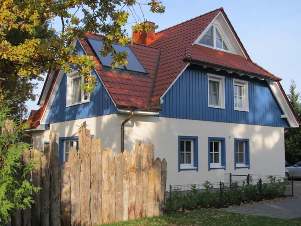 uma casa azul e branca com uma cerca de madeira em Ostseeträume-Zingst em Zingst