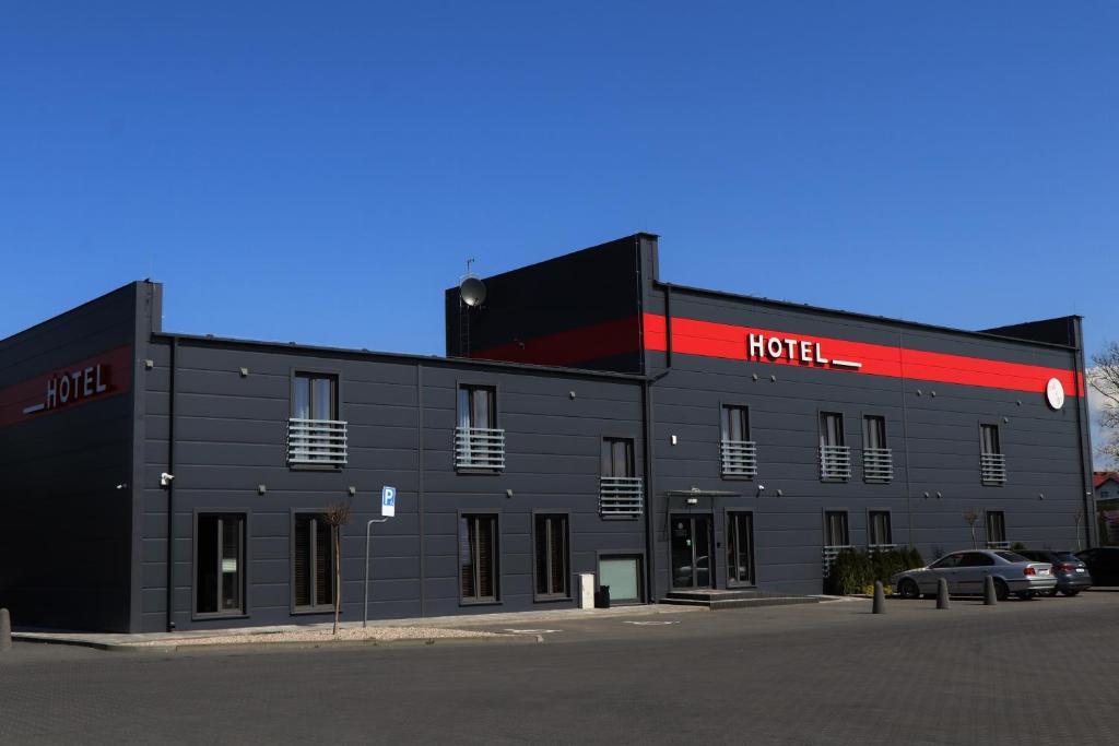 a black building with a hotel sign on it at M&W Hotel Wronowski in Łomża