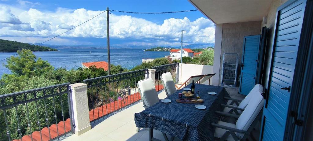 a balcony with a table and a view of the water at Leut in Nečujam
